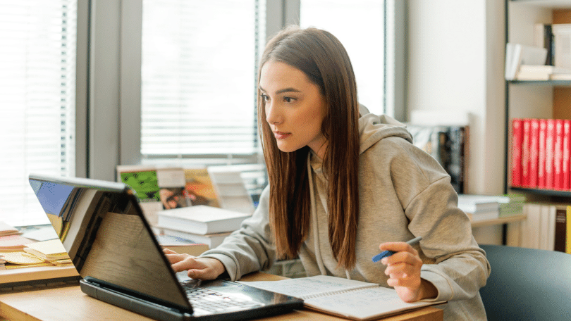 A female secondary school student is looking at a laptop while studying leaving cert german at premier tuition centre