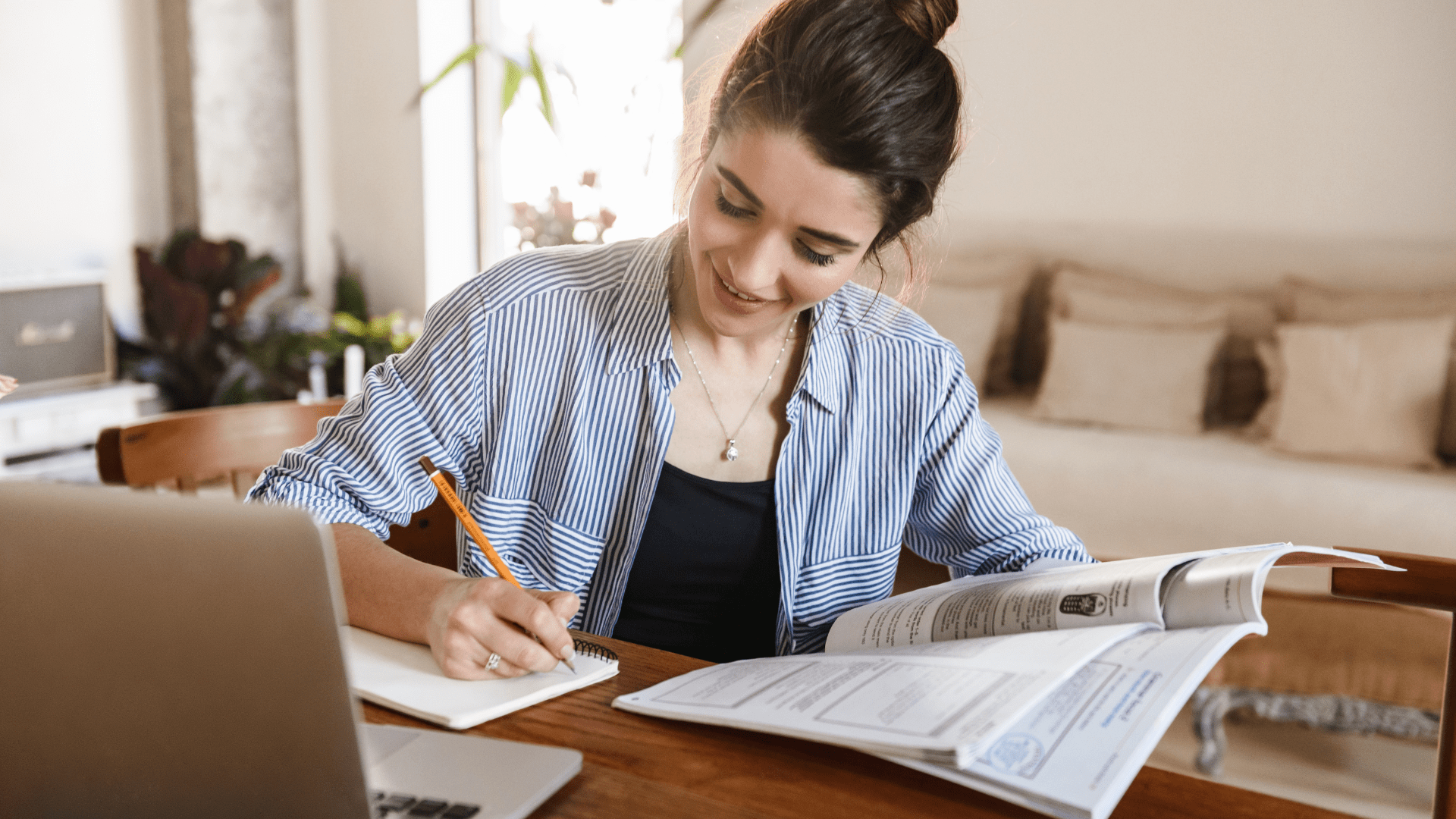 A female student sitting at a desk studying with a study habit checklist